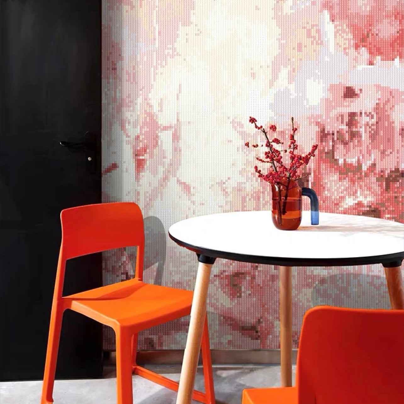 Modern interior with orange chairs and a round table against a textured wall.