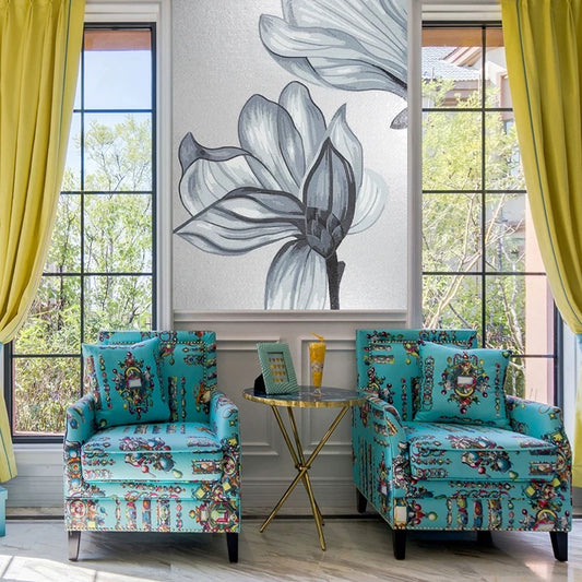 Two colorful armchairs in a room with large windows and floral artwork.